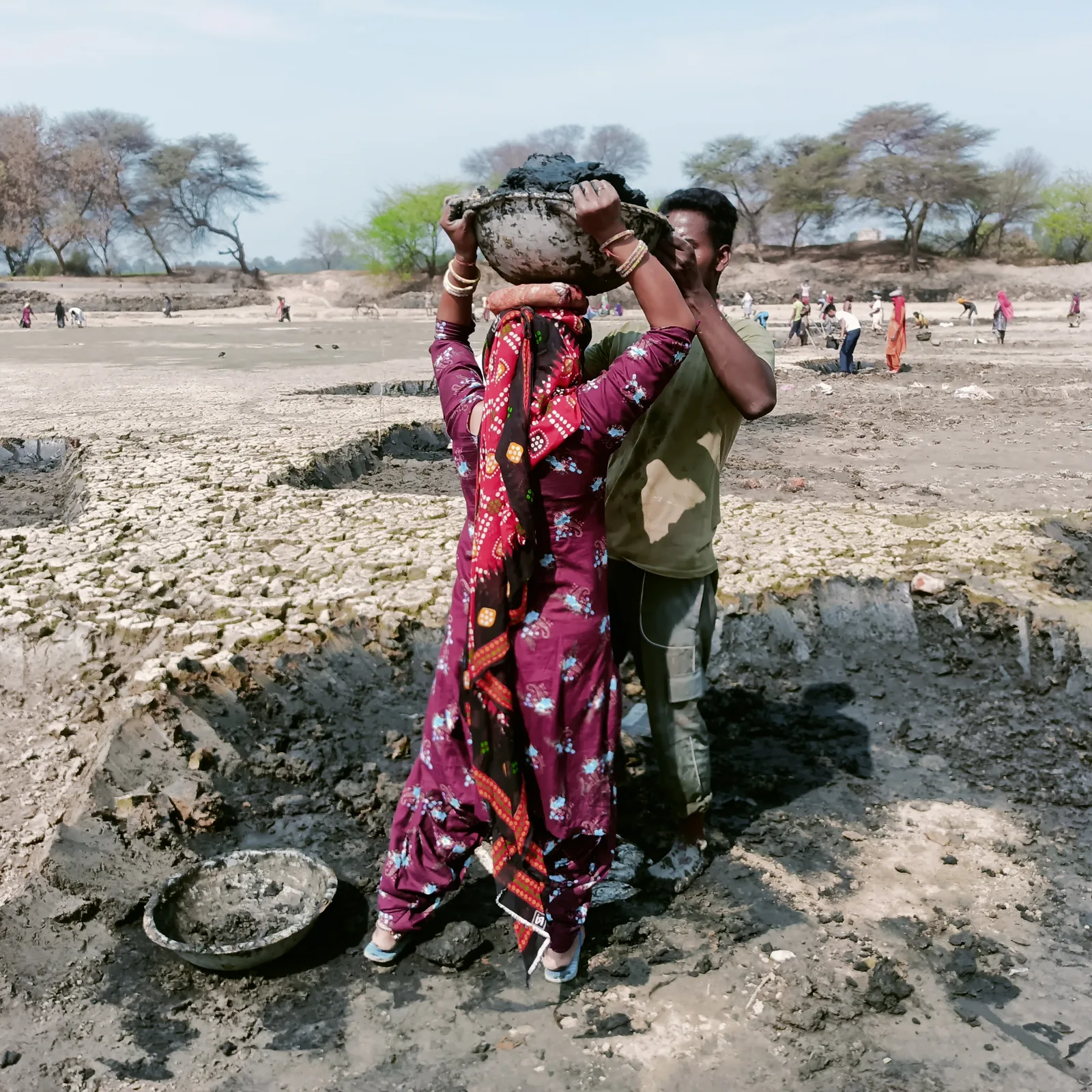 MGNREGA workers removing mud from a dry pond