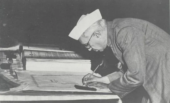 Members of the Constituent Assembly signed the handwritten Constitution of India: Archival photograph captioned as Nehru signing the Indian Constitution in New Delhi on 24 January 1950.