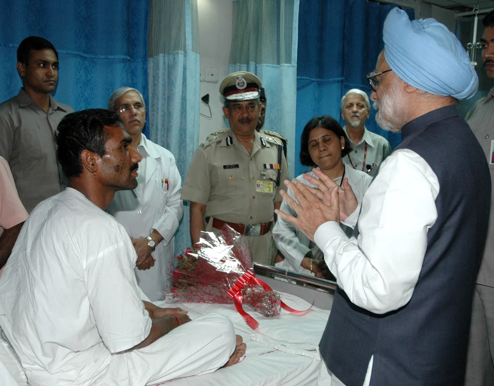 A suicide-bomber drives an explosives-laden automobile into the front gates of the Indian…: Manmohan Singh consoling injured ITBP driver Om Prakash Yadav following the July 2008 Indian Embassy Kabul suicide bombing; aftermath, not image of detonation. GODL exemptions review required.