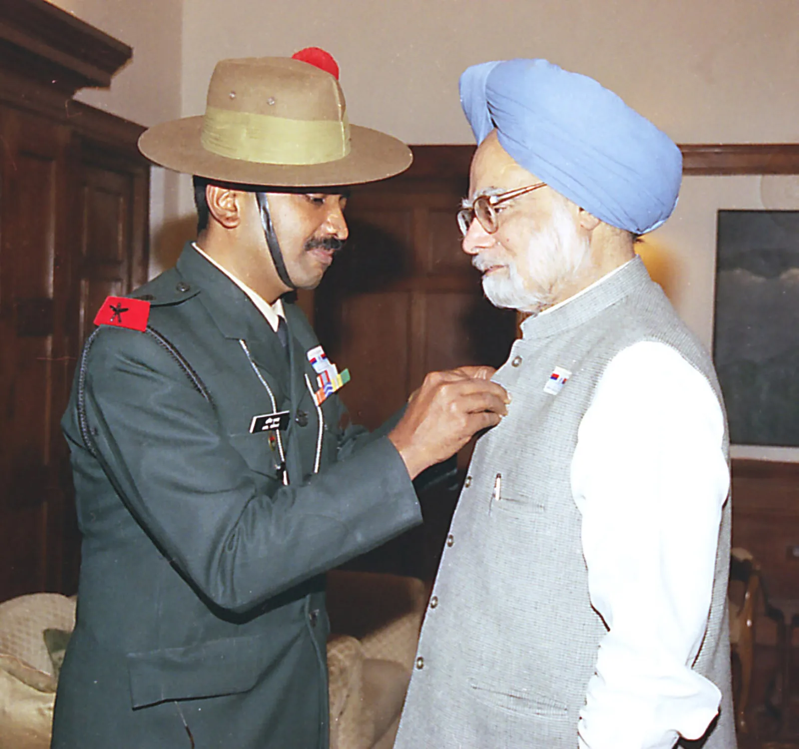 India begins observing Armed Forces Flag Day: Indian armed-forces personnel pin a commemorative flag on Prime Minister Manmohan Singh on 7 December 2004. Armed Forces Flag Day began in 1949; this is a later observance.